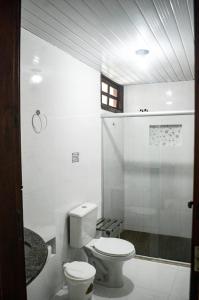 y baño blanco con aseo y ducha. en Pousada Coqueiro do Caitá, en Morro de São Paulo