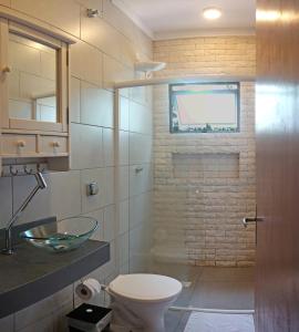 uma casa de banho com um WC, um lavatório e uma janela em Pousada Tubes Maresias em Maresias