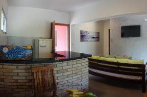 ein Wohnzimmer mit einem Sofa und einer Küche in der Unterkunft Pousada Tubes Maresias in Maresias