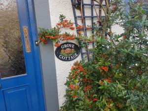 a sign on the side of a building with flowers at Boffin Lodge Guest House in Westport