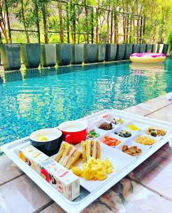 a tray of food on a table next to a pool at Shuei Wu Villa in Taichung