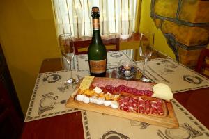 a table with a plate of food and a bottle of wine at Abundia Hotel Boutique de Turismo in Pelluhue