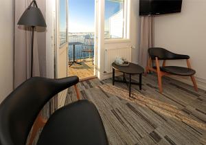 a living room with a chair and a table and a window at Hotel Icefiord in Ilulissat