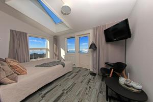 a bedroom with a bed and a flat screen tv at Hotel Icefiord in Ilulissat