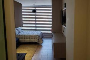 a bedroom with a bed and a window with blinds at Monoambiente de Lujo en Equipetrol - You in Santa Cruz de la Sierra +20 photos