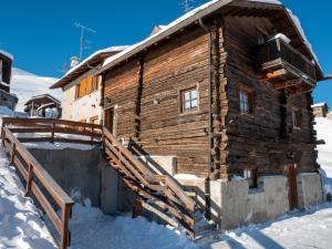 a log cabin in the snow with a ramp leading to it at Bait Nof - Trepalle in Livigno