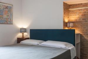 een bed met een blauw hoofdeinde in een slaapkamer bij Monti Garden in Rome
