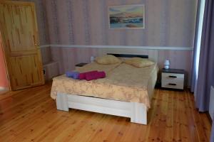 a small bed in a room with a wooden floor at Leču muiža in Lēči