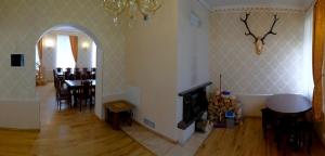 a living room with a table and a dining room at Leču muiža in Lēči
