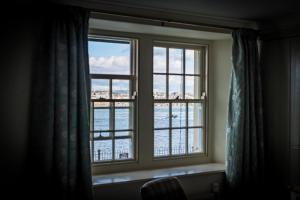 a window that is open with a view of the ocean at Edgcumbe Arms in Torpoint