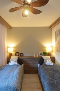 two beds in a bedroom with a ceiling fan at Sun&Sport apartament U MONI super lokalizacja niedaleko wyciągu in Szczyrk