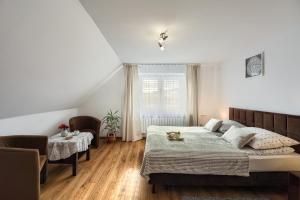 ティリチにあるRembiaszówkaのベッドルーム1室(ベッド1台、椅子2脚、窓付)
