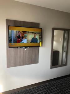 a television hanging on a wall with a mirror at Trolley Stop Motel, Media ,Near PHL Airport PA in Media