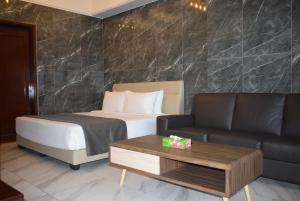 a hotel room with a bed and a couch at Grand Service Apartment @ Times Square in Kuala Lumpur