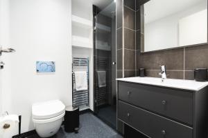 a bathroom with a sink and a toilet and a mirror at Hotel Icefiord in Ilulissat +37 photos