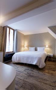 - une chambre avec un grand lit blanc et une fenêtre dans l'établissement Appart'Hôtel Sainte Trinité, à Troyes