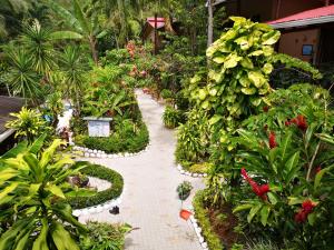 un jardin avec des plantes et des fleurs sur un chemin en briques dans l'établissement Hotel Belvedere Playa Samara Costa Rica, à Sámara