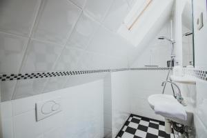 a white bathroom with a black and white checkered floor at B&B de Zandtaart in Egmond aan Zee +44 photos