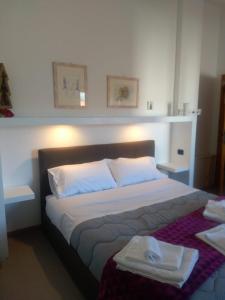 een slaapkamer met een groot bed en 2 handdoeken bij B&B MARIMA 2 POSTI ORGOSOLO in Orgosolo