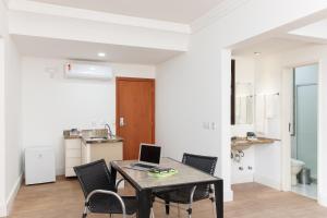 a dining room with a table with chairs and a laptop at Slaviero Hotel Vitória in Vitória