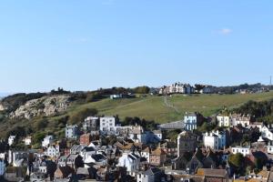 a city with houses and a hill in the background at Stunning 18th Century 5 Bed House Old-Town Hastings in Hastings