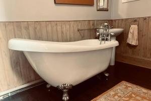 a white bath tub and a sink in a bathroom at Stunning 18th Century 5 Bed House Old-Town Hastings in Hastings +59 photos