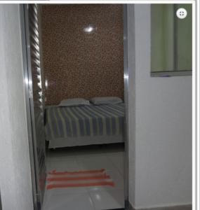 a small bedroom with a bed in a room at Pousada PG One in Praia Grande