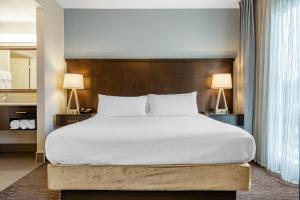 uma cama grande num quarto de hotel com duas lâmpadas em Staybridge Suites St. Petersburg FL, an IHG Hotel em St. Petersburg