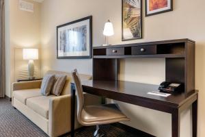 Staybridge Suites St. Petersburg FL, an IHG Hotel في سانت بطرسبرغ: غرفة في الفندق مع مكتب وأريكة