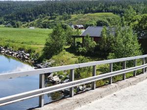 a bridge over a river with a building in the background at Marian's home in Skau