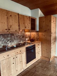 a kitchen with wooden cabinets and a sink and a stove at Ferienhaus Koch Weißbriach in Weissbriach
