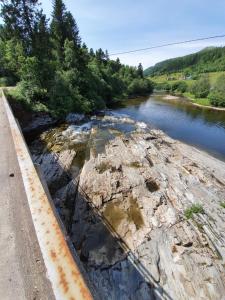 a river next to a road next to a body of water at Marian's home in Skau