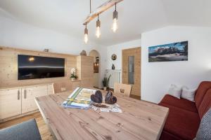 een woonkamer met een houten tafel en een tv bij Haus Pötzes in Castelrotto