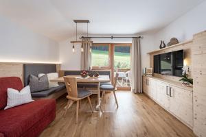 een woonkamer met een rode bank en een tafel bij Haus Pötzes in Castelrotto