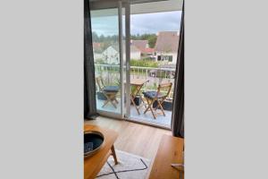 sala de estar con vistas a un balcón en Magnifique Appartement Sainte Cécile Plage, en Camiers
