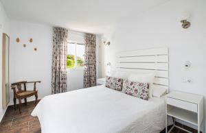 サオラにあるCasara Cinco - Hermosa Casa con Vista al Mar y Acceso Privado a la Playaの白いベッドルーム(白いベッド1台、窓付)