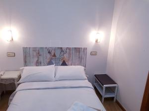 a bedroom with a white bed and two lights at Hotel Carabela La Pinta in Baiona