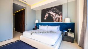 a bedroom with a bed with a painting of a horse on the wall at PIER 57 - 208 Best 2 BR Condo in Romantic Zone in Puerto Vallarta