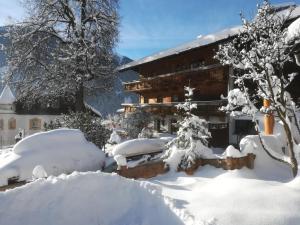 菲爾根的住宿－Mesnerhof Virgen，前面的雪覆盖的房子