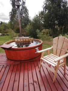 Alerce的住宿－Cabañas Troncos de Alerce en Puerto Montt con tinaja caliente，一个带喷泉的甲板上的椅子和浴缸