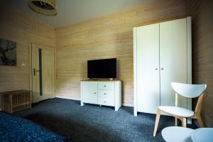 a bedroom with a television and a white cabinet at Brzozowy Gaj in Główczyce