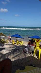 uma praia com cadeiras e guarda-sóis e o oceano em ILOA Residence Apt Completo na Barra de São Miguel