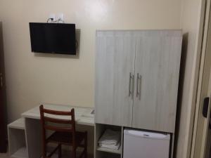 a room with a desk with a cabinet and a chair at Hotel Makuxis - Brigadeiro in São Paulo