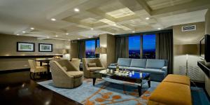 a living room with a couch and chairs and a table at Crowne Plaza Chicago O'Hare Hotel & Conference Center by IHG in Rosemont