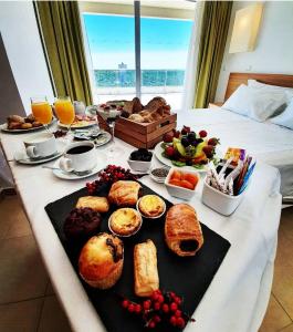 a breakfast table with bread and other foods on a bed at Monte Gordo Hotel Apartamentos & Spa in Monte Gordo