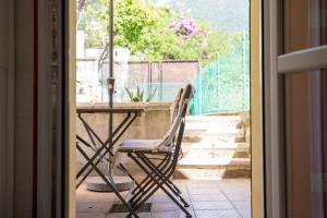 krzesło siedzące przy stole przed drzwiami w obiekcie La cà dei ulif w mieście Gardone Riviera