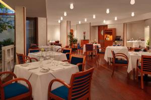 een restaurant met witte tafels en blauwe stoelen bij Crowne Plaza Milan Linate, an IHG Hotel in San Donato Milanese