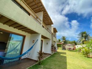 a room with a hammock on the side of a house at Arraia Suítes Pousada in Pipa