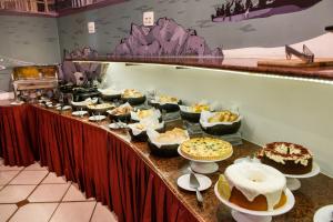 a buffet line with many different types of cakes and pies at Slaviero Hotel Vitória in Vitória