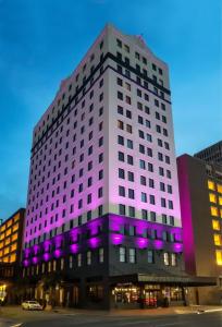 - un grand bâtiment blanc avec des lumières violettes dans l'établissement Hampton Inn & Suites New Orleans Canal St. French Quarter, à La Nouvelle-Orléans